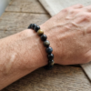 Bracelet lithotherapie Obsidienne oeil celeste sur poignet par Romain Creation