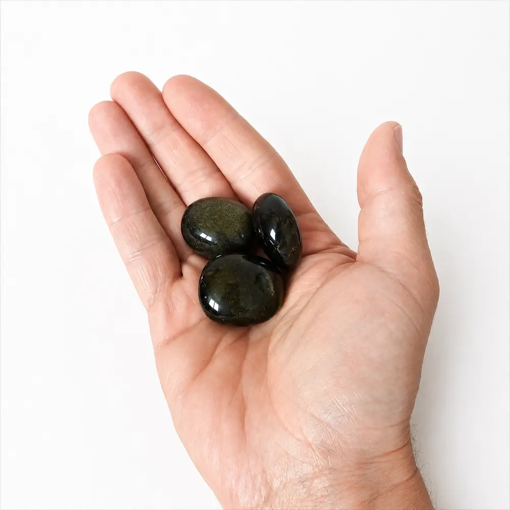 pierres roulées obsidienne dorée dans paume de main par romain creation